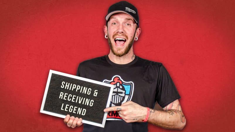 Image of Erick holding a sign that says Shipping & Receiving Legend